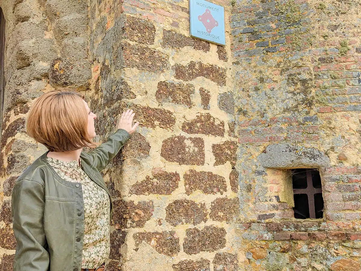 Une médiatrice lors d'une visite guidée devant le porche d'entrée de la Commanderie d'Arville.