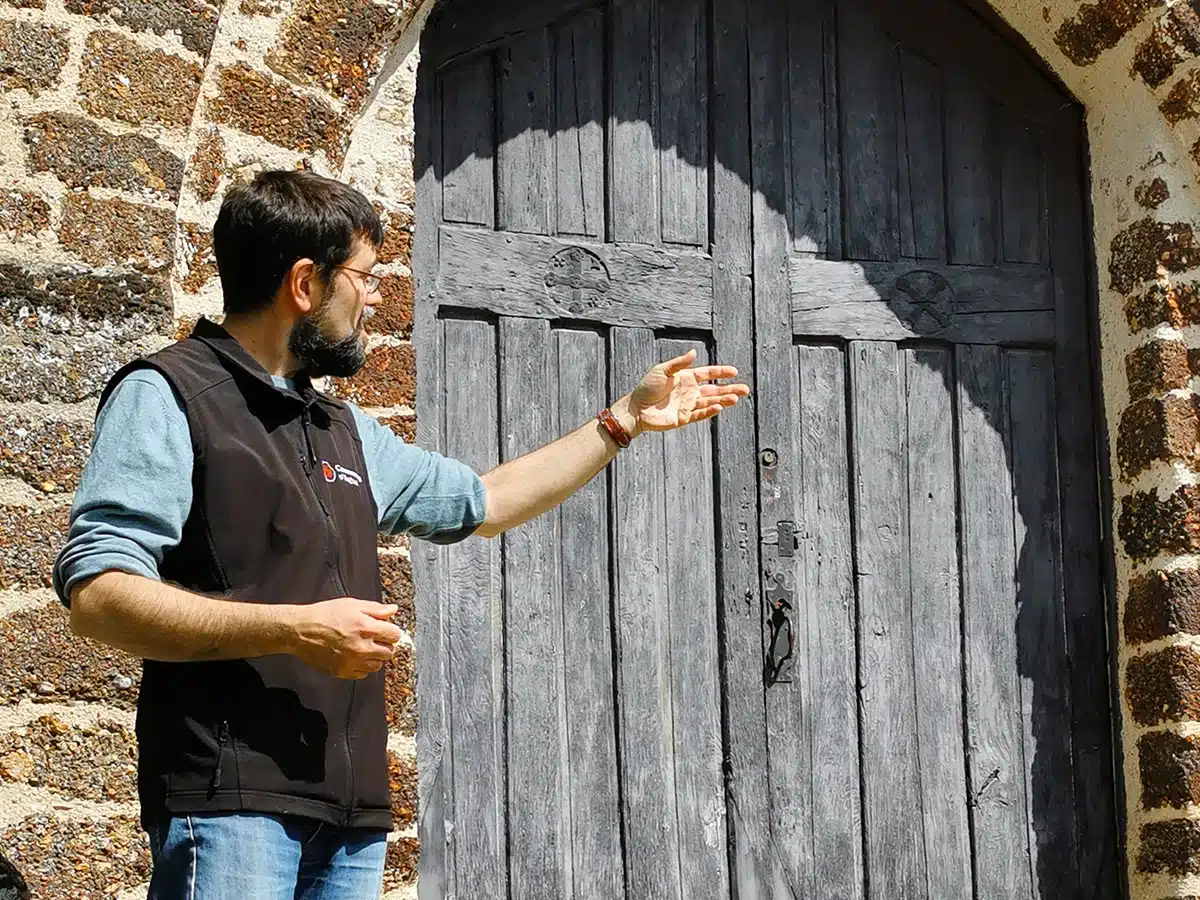 Un médiateur lors d'une visite guidée devant l'église des Templiers de la Commanderie d'Arville.
